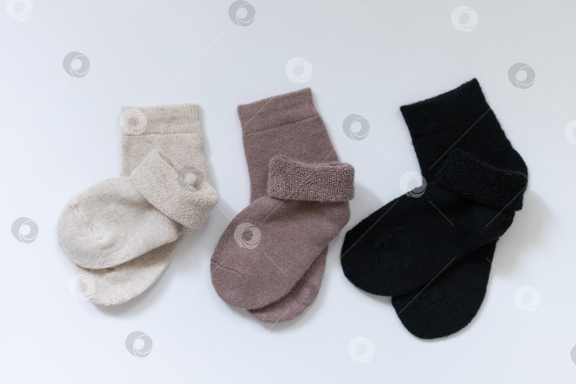 Скачать Три пары теплых носков на белом фоне, белые, коричневые, черные фотосток Ozero