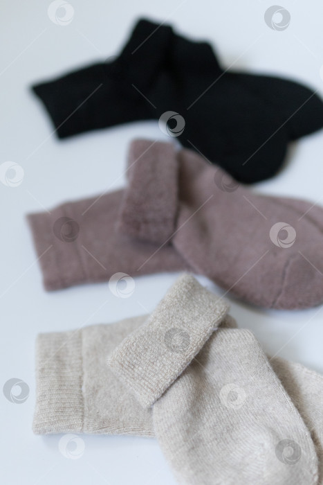 Скачать Три пары теплых носков на белом фоне, белые, коричневые, черные фотосток Ozero