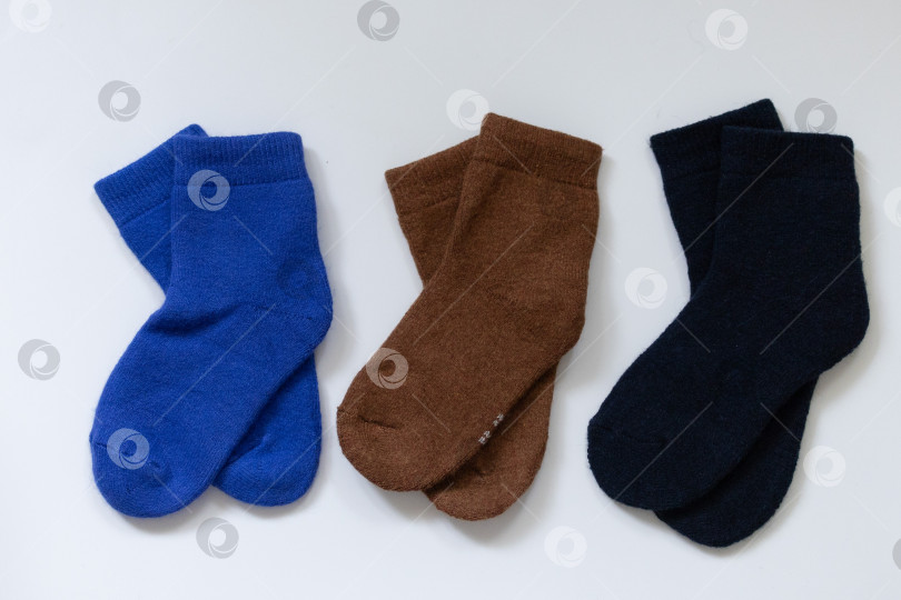 Скачать Три пары теплых носков на белом фоне, синем, коричневом, черном фотосток Ozero