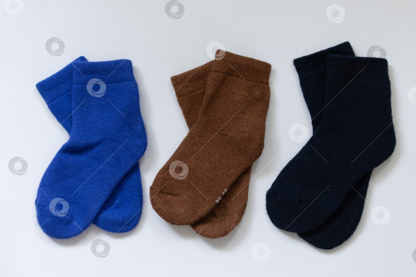 Скачать Три пары теплых носков на белом фоне, синем, коричневом, черном фотосток Ozero