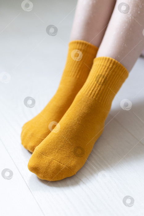 Скачать Детские ножки в синих носочках на белом фоне фотосток Ozero