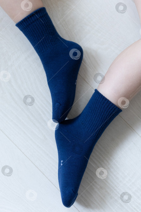 Скачать Детские ножки в синих носочках на белом фоне фотосток Ozero