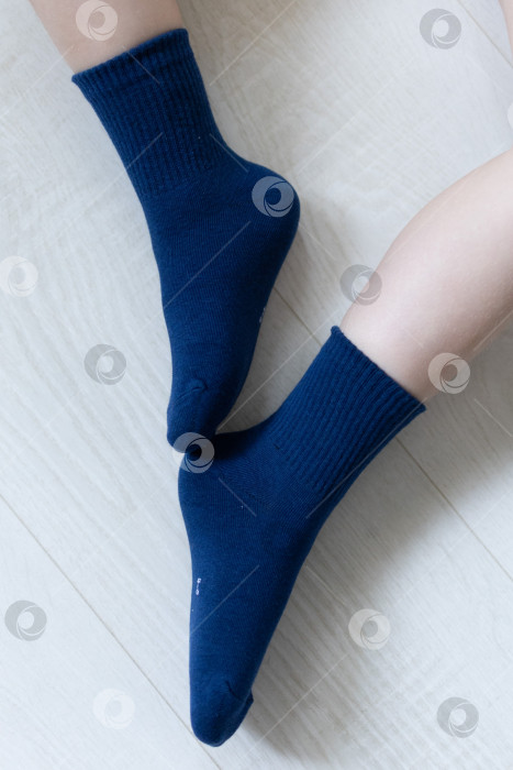 Скачать Детские ножки в синих носочках на белом фоне фотосток Ozero