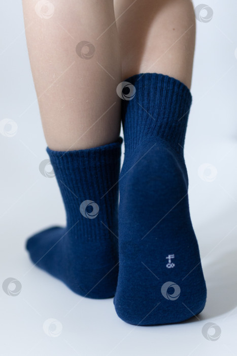 Скачать Детские ножки в синих носочках на белом фоне фотосток Ozero