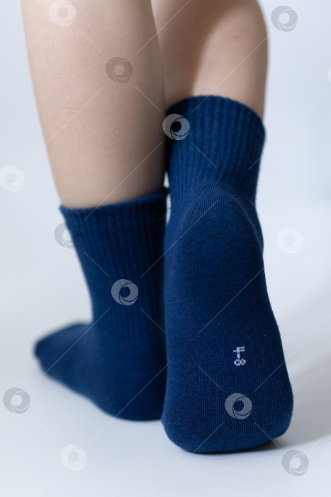 Скачать Детские ножки в синих носочках на белом фоне фотосток Ozero