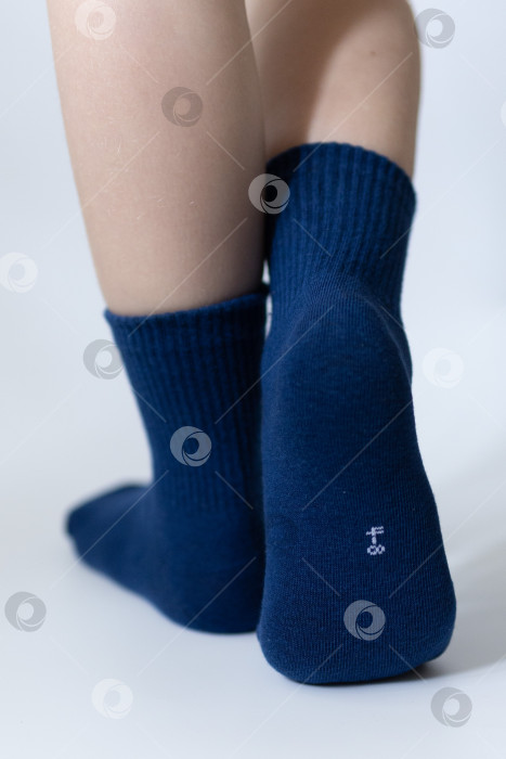 Скачать Детские ножки в синих носочках на белом фоне фотосток Ozero