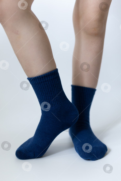 Скачать Детские ножки в синих носочках на белом фоне фотосток Ozero