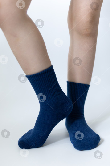 Скачать Детские ножки в синих носочках на белом фоне фотосток Ozero
