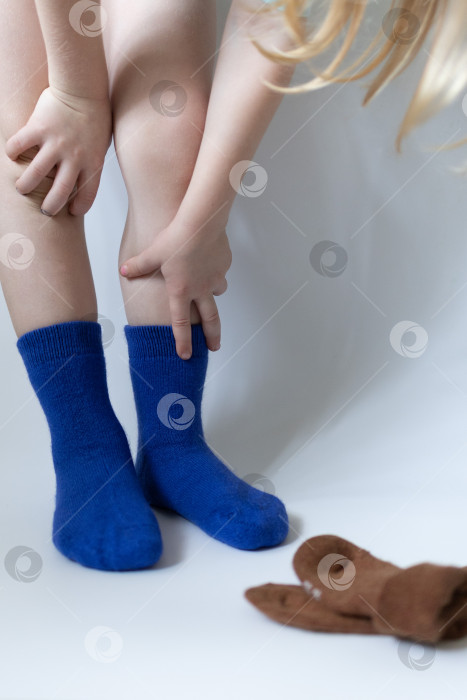 Скачать Детские ножки в синих носочках на белом фоне фотосток Ozero