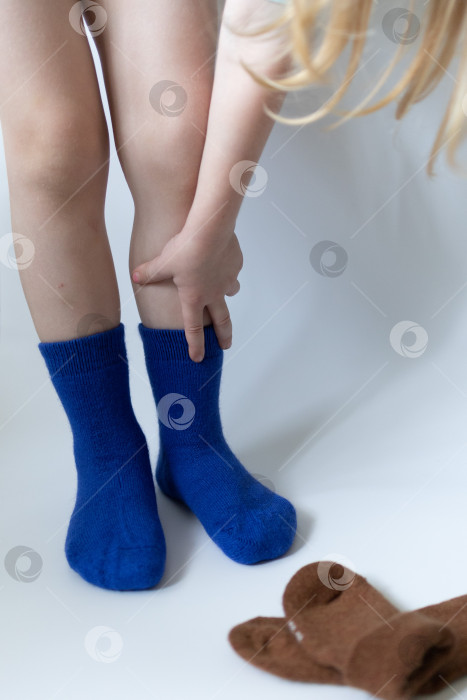 Скачать Детские ножки в синих носочках на белом фоне фотосток Ozero