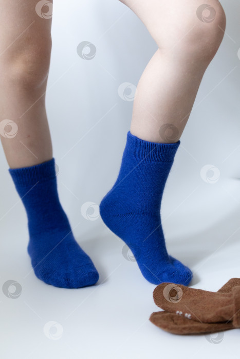 Скачать Детские ножки в синих носочках на белом фоне фотосток Ozero