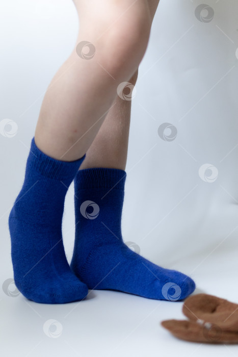 Скачать Детские ножки в синих носочках на белом фоне фотосток Ozero