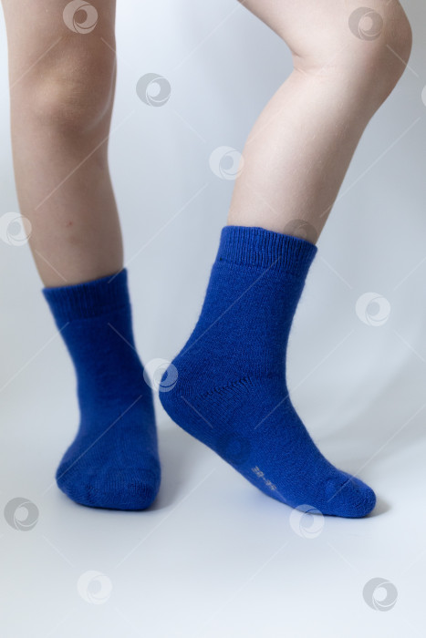 Скачать Детские ножки в синих носочках на белом фоне фотосток Ozero