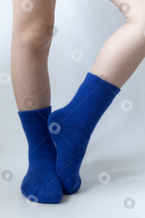 Скачать Детские ножки в синих носочках на белом фоне фотосток Ozero