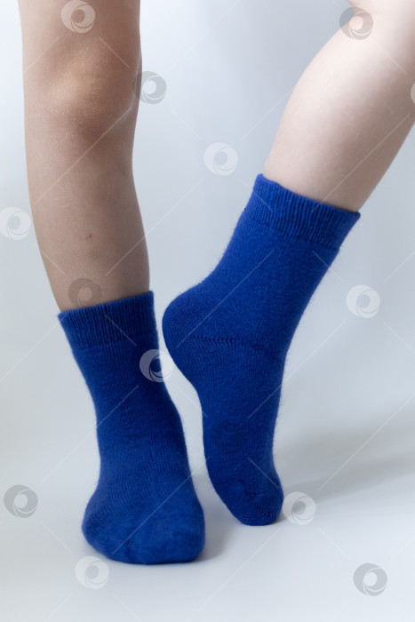 Скачать Детские ножки в синих носочках на белом фоне фотосток Ozero