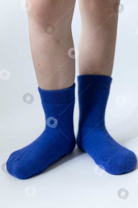 Скачать Детские ножки в синих носочках на белом фоне фотосток Ozero