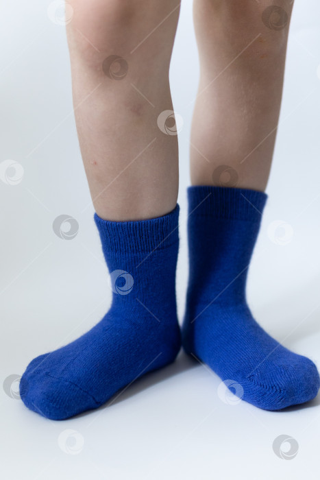 Скачать Детские ножки в синих носочках на белом фоне фотосток Ozero