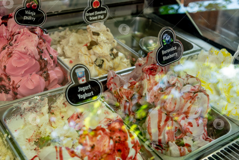 Скачать Будва, Черногория, 21 мая 2025 года, Продается Вкусное фруктовое мороженое разных цветов в контейнерах на витрине фотосток Ozero