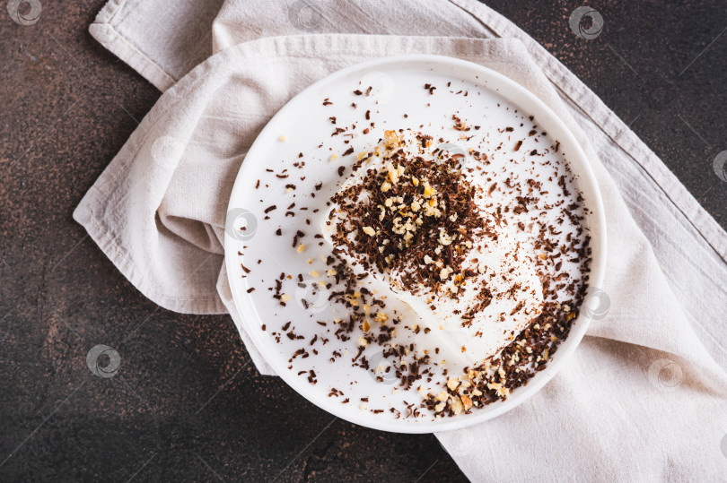 Скачать Крупный план мороженого, посыпанного шоколадной крошкой и орехами, на тарелке на столе, вид сверху фотосток Ozero