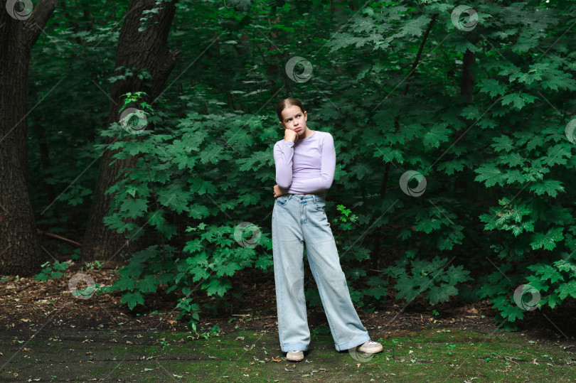 Скачать Thoughtful teenage girl standing in the forest during the day фотосток Ozero