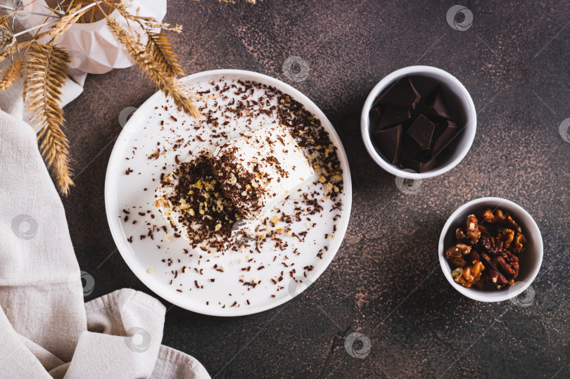 Скачать Ice cream sprinkled with chocolate chips and nuts on a plate on the table top view фотосток Ozero