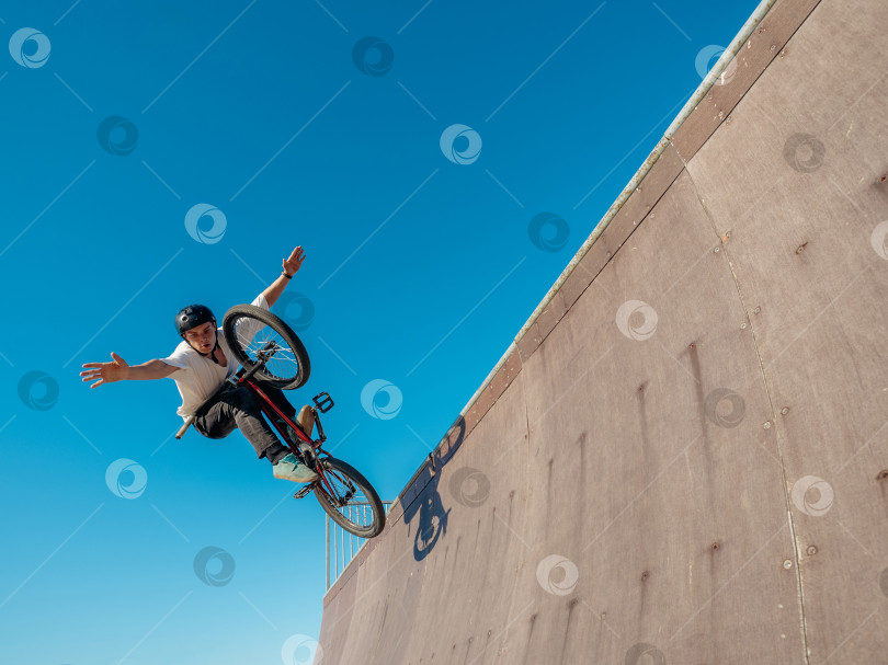 Скачать Велосипедист BMX выполняет трюк без рук в хафпайпе фотосток Ozero
