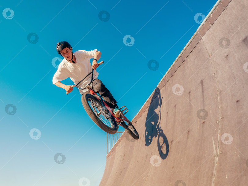 Скачать Велогонщик BMX выполняет трюк в хафпайпе фотосток Ozero