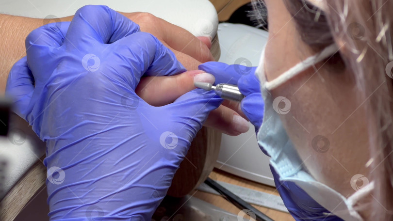 Скачать Уход за кутикулой. Косметолог подстригает кутикулу клиентки. Маникюрный салон. видео фотосток Ozero