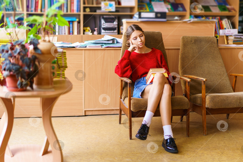 Скачать Посмотрите на красивую молодую женщину с интересной книгой в руках. Она читает фотосток Ozero