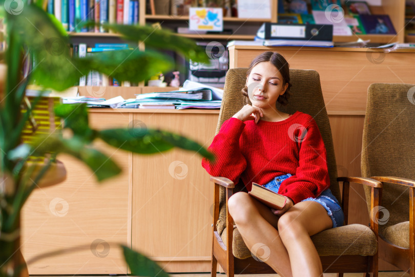 Скачать Веселая молодая брюнетка смеется над забавной историей из книги, счастливая фотосток Ozero