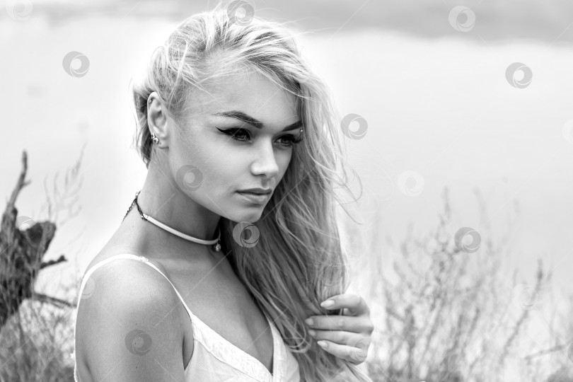 Скачать Белокурая женщина с длинными волосами стоит в поле фотосток Ozero