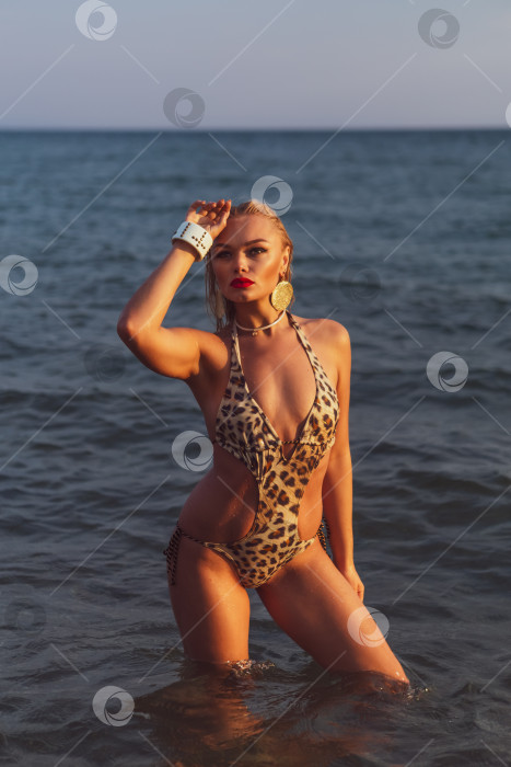 Скачать Женщина в бикини с леопардовым принтом стоит в океане фотосток Ozero