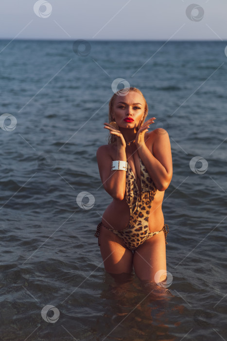 Скачать Женщина в бикини с леопардовым принтом стоит в океане фотосток Ozero