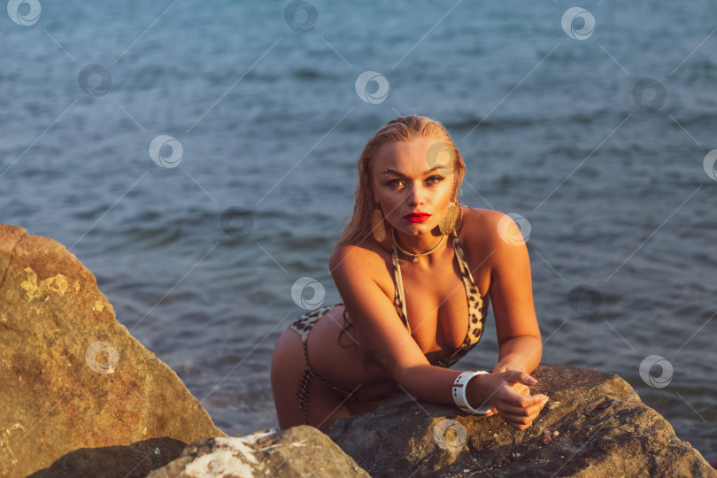 Скачать Женщина в бикини лежит на камне у воды фотосток Ozero