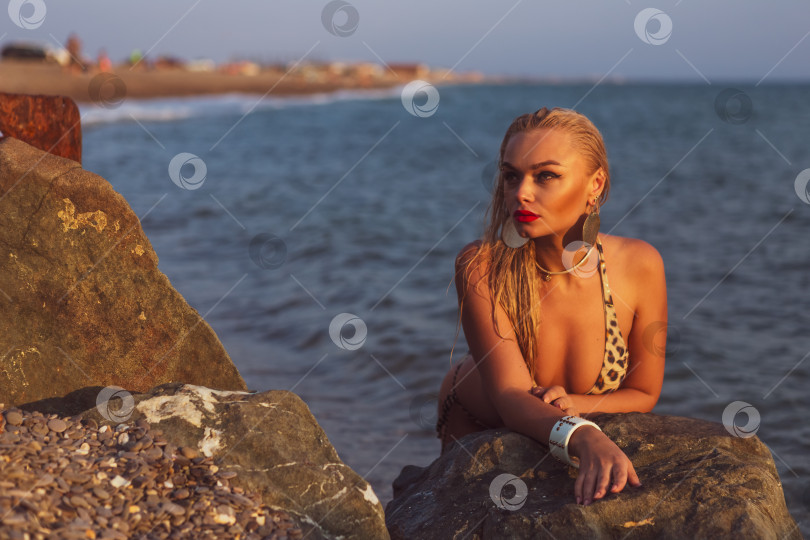 Скачать Женщина лежит на скале у океана. фотосток Ozero