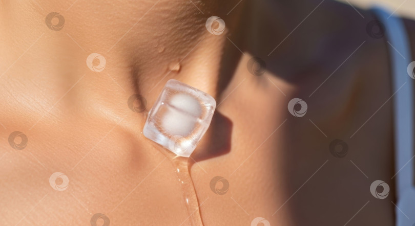 Скачать Крупный план женского тела с тающим на коже кубиком льда. Капли воды мгновенно охлаждают кожу после летней жары. Концепция увлажнения и хорошего самочувствия. фотосток Ozero
