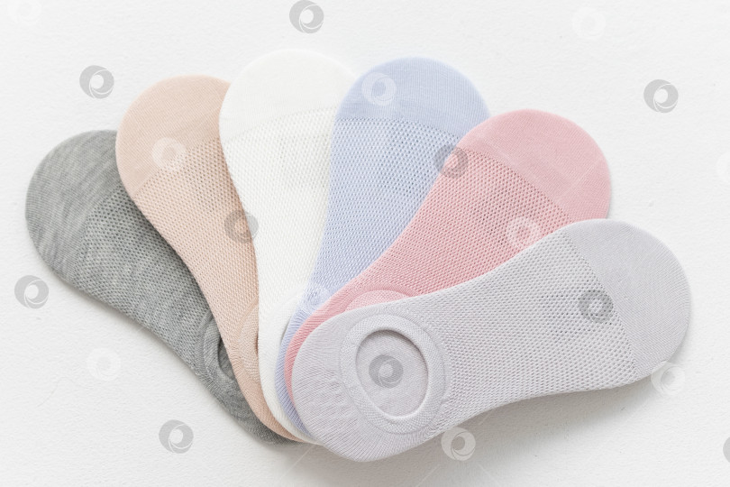 Скачать Короткие летние носки пастельных тонов на белом фоне. вид сверху. расположение веером фотосток Ozero