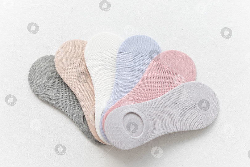 Скачать Короткие летние носки пастельных тонов на белом фоне. вид сверху. расположение веером фотосток Ozero