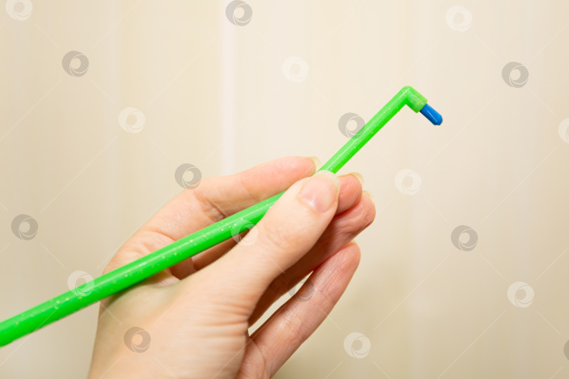 Скачать Зеленая зубная щетка с одним пучком для брекетов в руке. фотосток Ozero