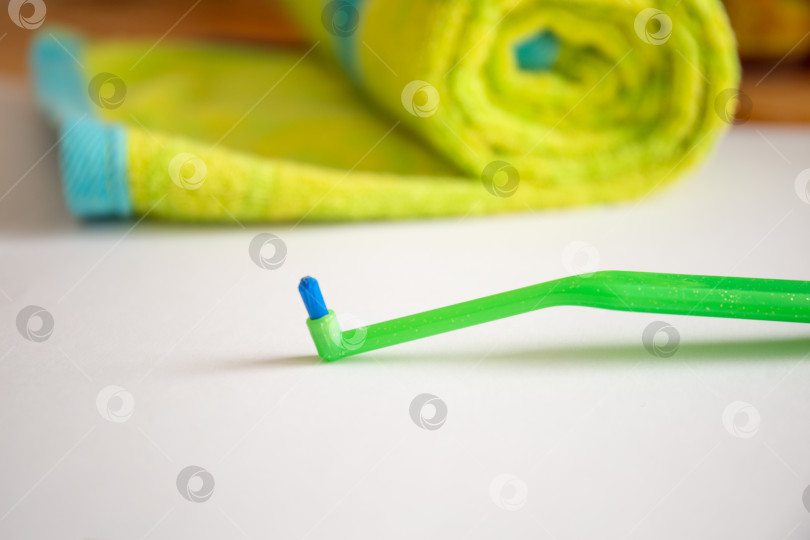 Скачать Зеленая зубная щетка с одним пучком для брекетов на столе фотосток Ozero