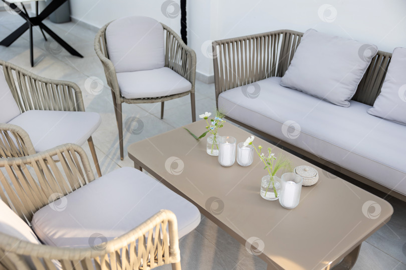 Скачать Современное жилое пространство с мягкими серыми креслами и декоративным украшением в центре со свечами и цветами в яркой минималистской обстановке. фотосток Ozero