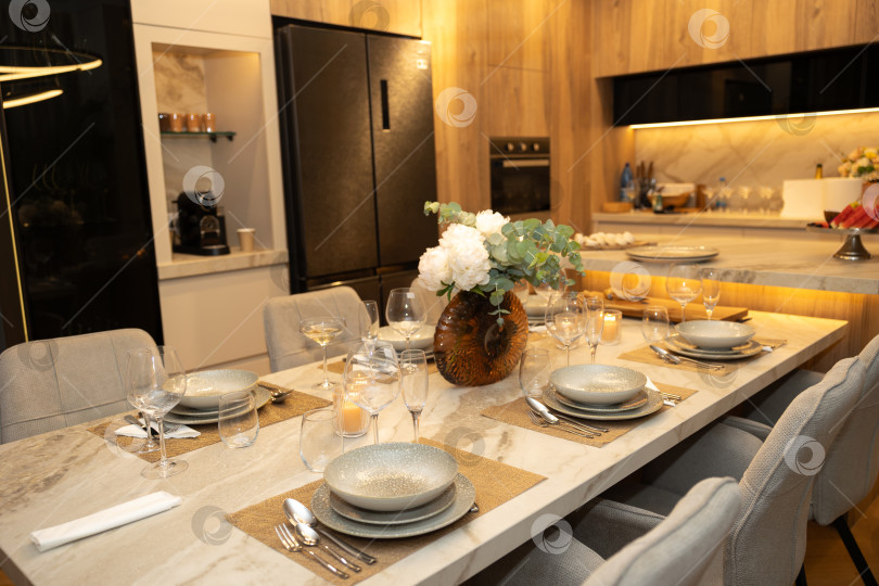 Скачать Элегантный ужин с изысканной сервировкой стола, стильной посудой и современной кухонной обстановкой. фотосток Ozero