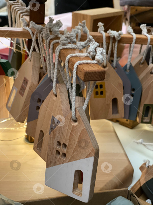 Скачать Деревянные украшения в форме домика, выставленные на всеобщее обозрение, подходят для оформления праздничного или домашнего декора. фотосток Ozero