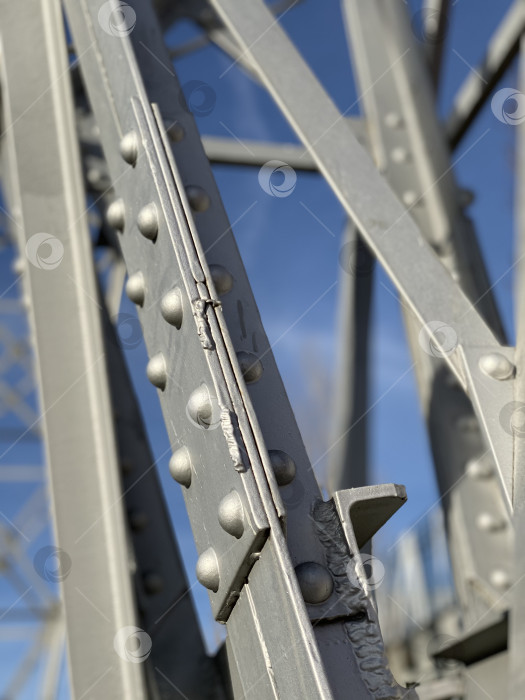 Скачать Крупный план стальных балок с заклепками на фоне голубого неба, создающий индустриальный фон фотосток Ozero