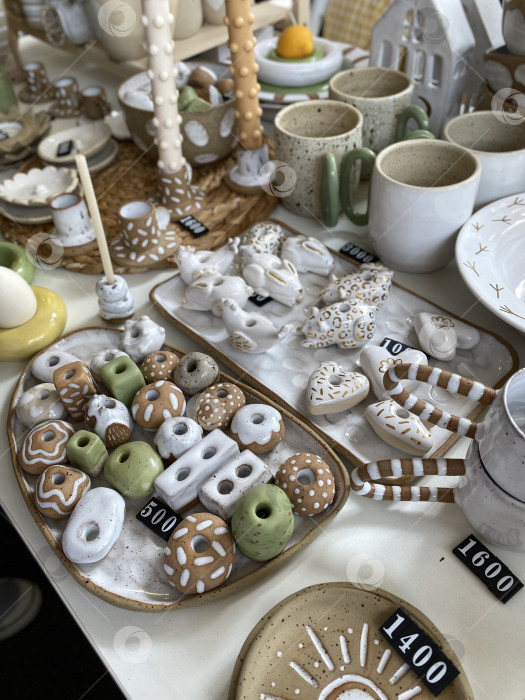 Скачать Керамические украшения ручной работы, выставленные на стол с ценниками, идеально подходят для праздничного фона фотосток Ozero