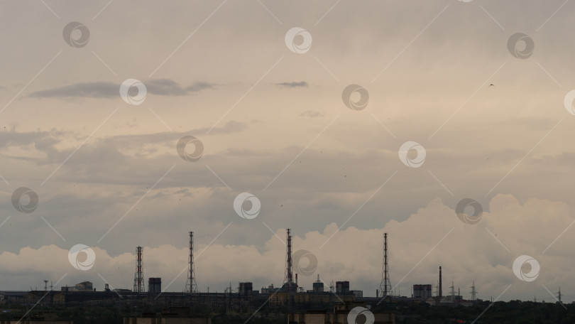 Скачать Фабрики и опоры ЛЭП тянутся вдоль горизонта под грозовым небом фотосток Ozero