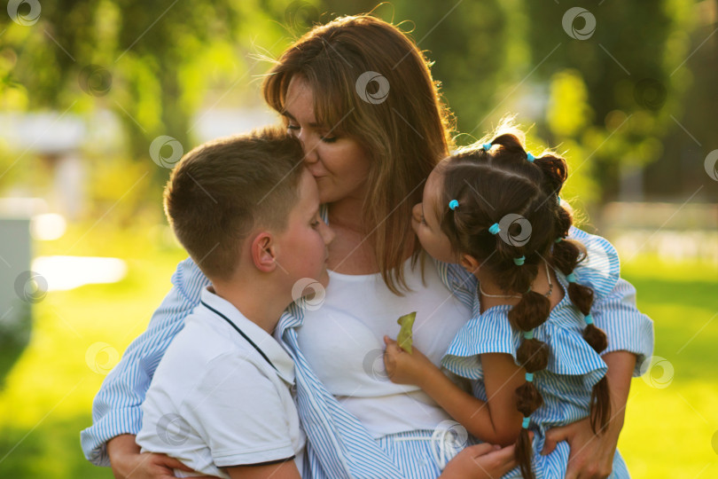 Скачать Мама целует сына в лоб, а дочь наблюдает за этим фотосток Ozero