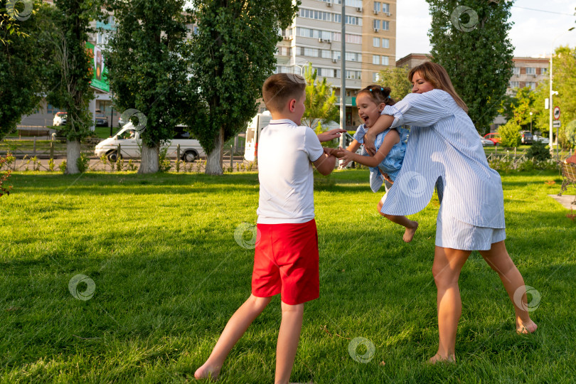 Скачать Родители поворачивают дочь к брату во время оживленной игры в парке фотосток Ozero