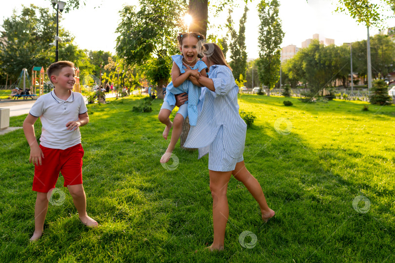 Скачать Смеющаяся девушка приподнимается, а брат бежит рядом. фотосток Ozero