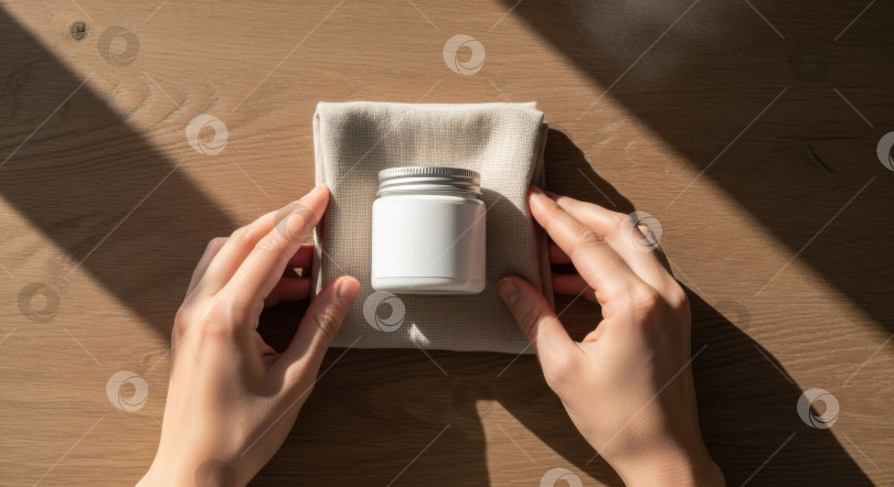 Скачать Женская рука поправляет баночку для ухода за кожей на ткани. Макет косметологических и косметических товаров. Деревянный фон для рекламы товаров для здоровья. фотосток Ozero
